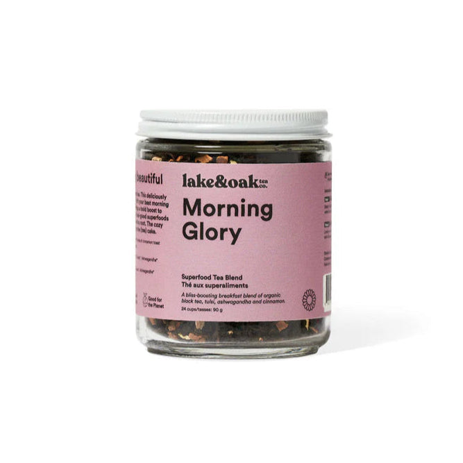 A glass jar of Lake & Oak Morning Glory tea with a pink label, containing a superfood breakfast tea blend.