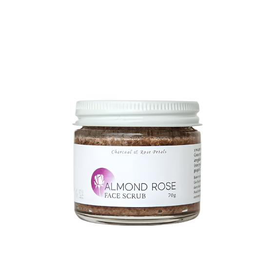 A glass jar with a metal lid containing Almond Rose Facial Scrub, with a white label that includes the product name and a brief description.