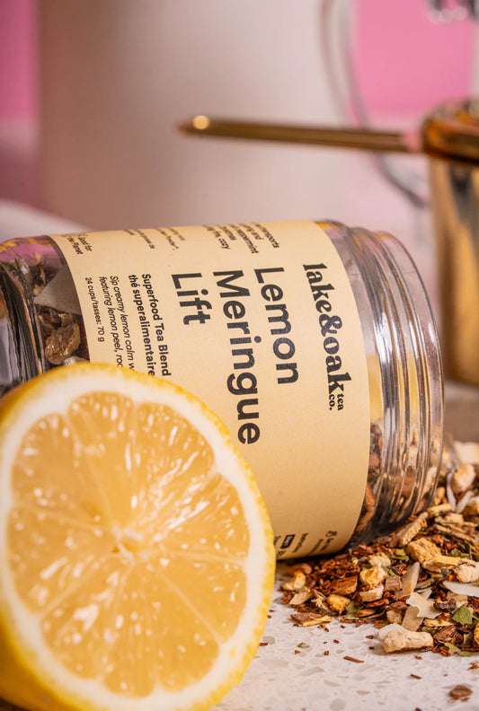 A jar of 'Lemon Meringue Lift' tea with a sliced lemon next to it.