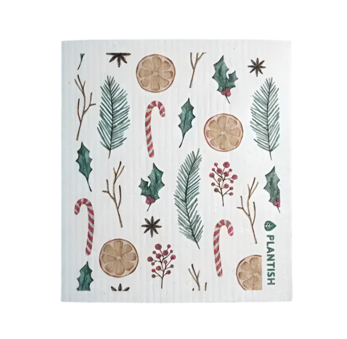 A Plantish Swedish Dish Sponge with small festive designs all over it including balsam branches, orange slices, candy canes, and assorted greenery.